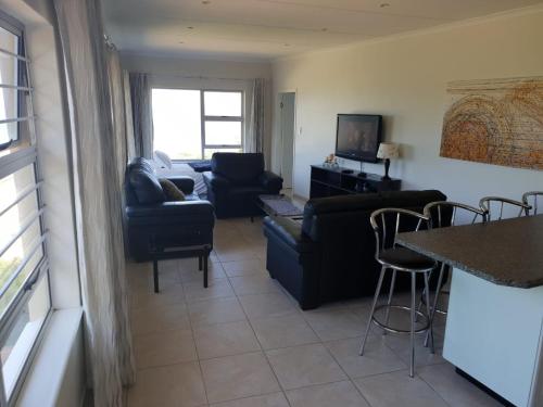 una sala de estar con un sofá y una mesa en SEA4EVER, en Port Shepstone