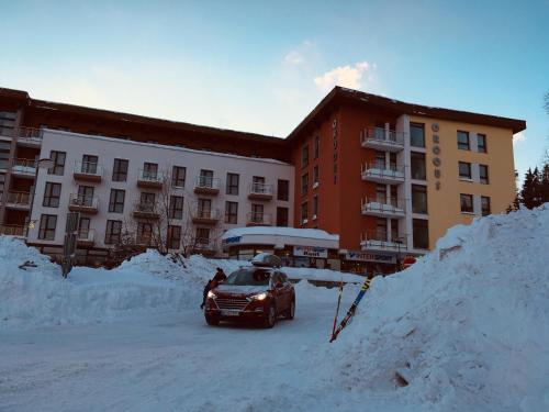 a car parked in the snow in front of a building at Apartmán Crocus 313 in Štrbské Pleso