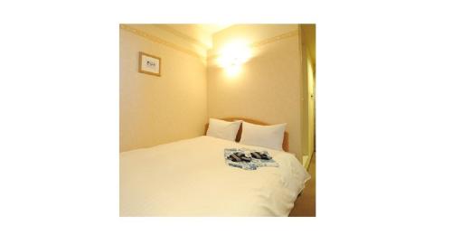 ein kleines Schlafzimmer mit einem Bett mit weißer Bettwäsche in der Unterkunft Yonezawa - Hotel / Vacation STAY 14342 in Yonezawa