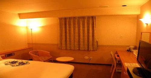 Zimmer mit einem Tisch und einem Schreibtisch mit einem Tisch und einem Tisch in der Unterkunft Hotel Benex Yonezawa / Vacation STAY 14346 in Yonezawa