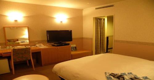 a hotel room with a bed and a desk and a television at Hotel Benex Yonezawa / Vacation STAY 14346 in Yonezawa