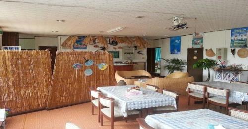 ein Restaurant mit Tischen und Stühlen in einem Zimmer in der Unterkunft Oshima-gun - Hotel / Vacation STAY 14391 in Furusato