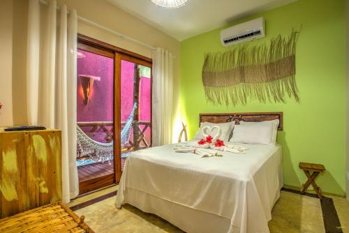 a bedroom with a white bed with flowers on it at Raio de Sol Pousada in Itacaré