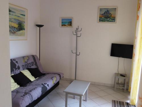 a living room with a purple couch and a tv at Villa avec piscine in Cap d'Agde