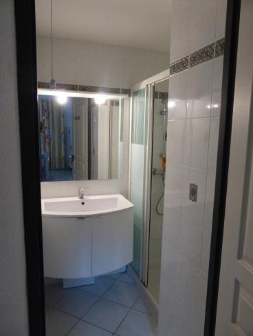 une salle de bain blanche avec un lavabo et une douche dans l'établissement Villa avec piscine, au Cap d'Agde