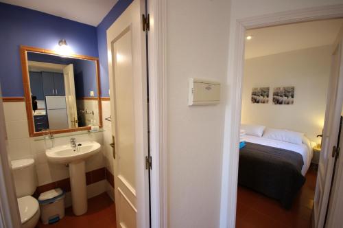 La salle de bains est pourvue d'un lavabo et d'un lit dans la chambre. dans l'établissement Livingtarifa Apartamento Serendipia, à Tarifa