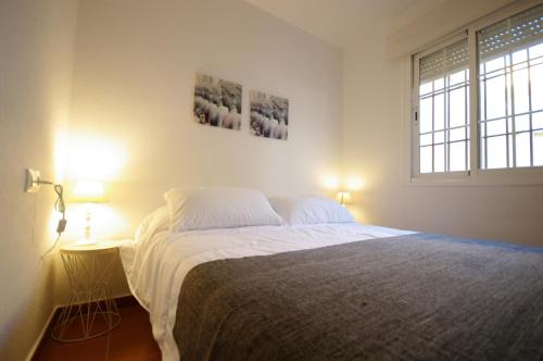 - une chambre avec un grand lit et 2 fenêtres dans l'établissement Livingtarifa Apartamento Serendipia, à Tarifa