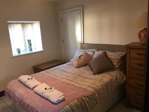 ein Schlafzimmer mit einem Bett mit zwei Handtüchern darauf in der Unterkunft Sedbury Farm Cottages in Chepstow
