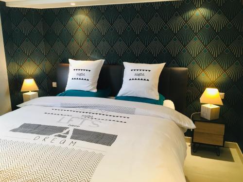 a bedroom with a large bed with two pillows at Gîte de la Vallée in Dambach