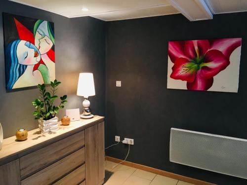 a living room with two paintings on the wall at Gîte de la Vallée in Dambach
