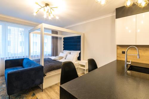 a bedroom with a bed and a kitchen with a table at Fabulous apartment in heart of Katowice in Katowice