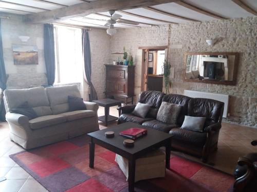 ein Wohnzimmer mit Sofa und Tisch in der Unterkunft La Pommeraie in Nantillé