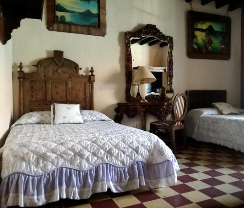 1 dormitorio con cama y espejo en Posada San Sebastian en Antigua Guatemala
