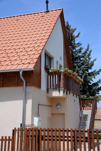 a house with a balcony with flowers on it at Arany Szőlő Wellness Apartmanház in Hévíz