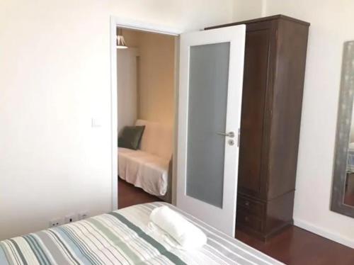 une chambre avec une porte s'ouvrant sur une chambre avec un lit dans l'établissement Amazing flat in Madragoa, à Lisbonne