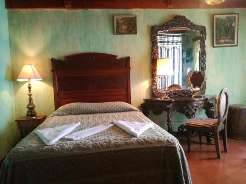 1 dormitorio con cama, espejo y mesa en Posada San Sebastian en Antigua Guatemala