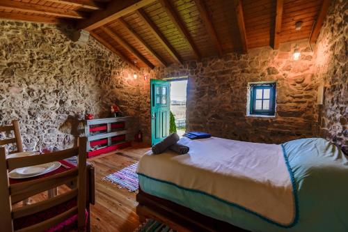1 dormitorio con 1 cama en una habitación con ventana en Casa Rústica, perto do Castelo de Óbidos, en Óbidos