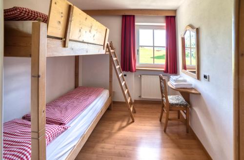 a small room with two bunk beds and a desk at Residenz am Kaiserweg in Longomoso