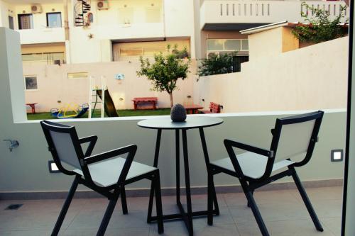 two chairs and a table on a balcony with a table at Luxury Apartments Near to the beach in Plakias