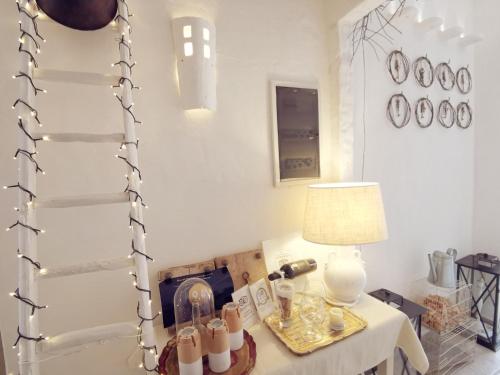 a room with a table with a lamp and glasses on it at Le Nicchie Guest House in Lucera