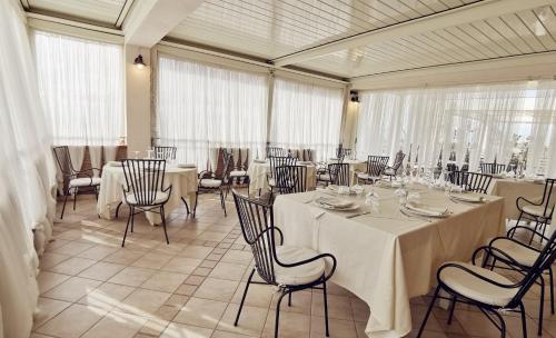 a dining room with tables and chairs and windows at Le Nicchie Guest House in Lucera
