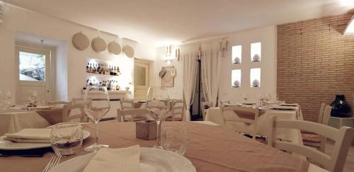 a dining room with white tables and white chairs at Le Nicchie Guest House in Lucera