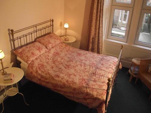 a bedroom with a bed and two tables and a window at The Old Rectory in Annan