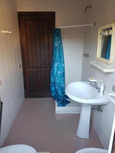 un bagno con lavandino, servizi igienici e porta di Domusmare villetta a Capitana