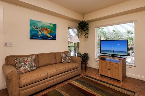 a living room filled with furniture and a tv at Bridgewalk, a Landmark Resort in Bradenton Beach