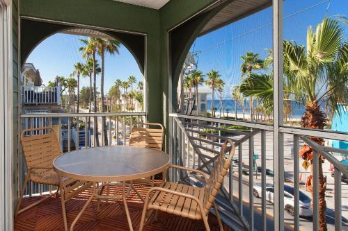 a patio area with chairs, tables and umbrellas at Bridgewalk, a Landmark Resort in Bradenton Beach