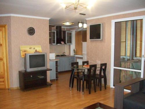 salon ze stołem i telewizorem oraz kuchnia w obiekcie 1 комнатная квартира студио возле ТРЦ Днепроплаза w Czerkasach
