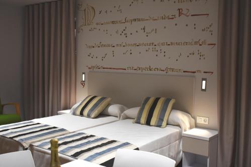 dwa łóżka siedzące obok siebie w pokoju w obiekcie Apartamentos Turísticos Pueri Cantores w mieście Burgos