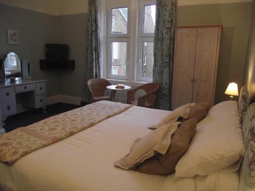 a large bed in a bedroom with a window at The Old Rectory in Annan