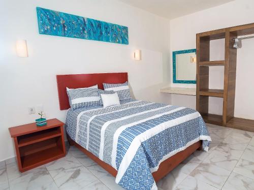 ein Schlafzimmer mit einem Bett und einem Holztisch in der Unterkunft Villa Alebrije Cozumel in Cozumel