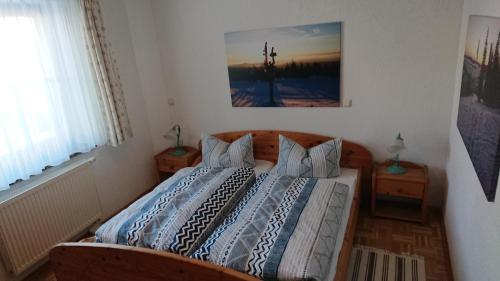 a bedroom with a bed and a picture on the wall at Ferienwohnung Korn mit Tiefgarage und Skiraum in Kurort Oberwiesenthal