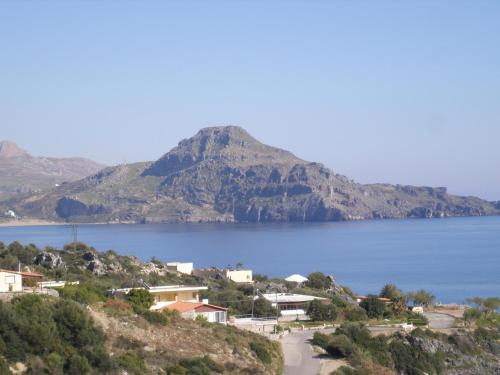 a view of a large body of water with a mountain at Eolia beachfront studios in Plakias