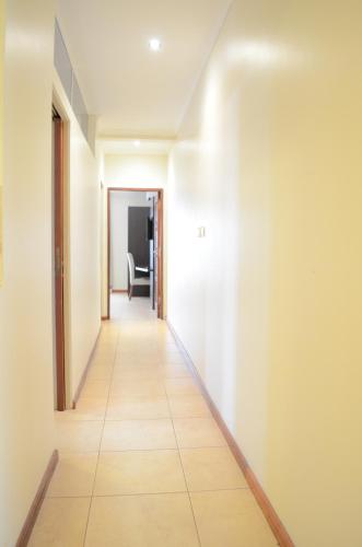 a hallway with white walls and a tile floor at Hotel Jardin De Iguazu in Puerto Iguazú