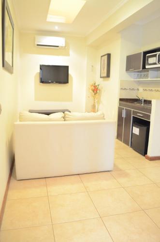 a living room with a tv on the wall at Hotel Jardin De Iguazu in Puerto Iguazú