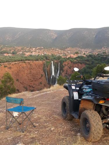 a chair and a jeep and a chair and waterfall at Chambre d'hôtes aya in Ouzoud