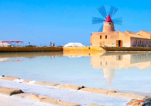 a windmill in the middle of a body of water at B&B Profumi di Sicilia in Valderice