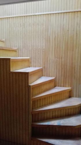 a set of wooden stairs in a building at Tres de junio in Puerto Montt