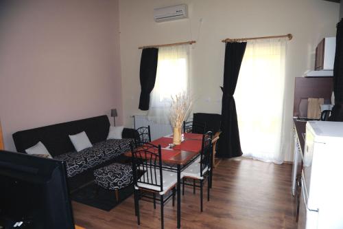a living room with a table and a couch at Arany Szőlő Wellness Apartmanház in Hévíz