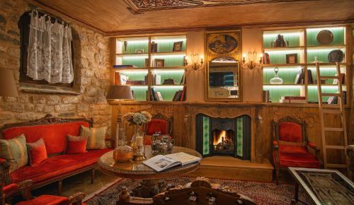 a living room with a fireplace and red chairs at KAMARES Historic Boutique Hotel & Spa in Ioannina