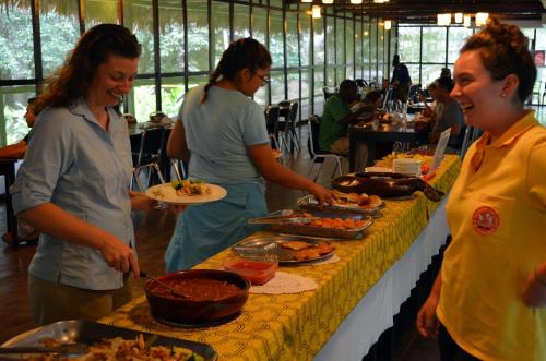 een groep vrouwen die rond een buffet staan met eten bij Explorama Lodge in Francisco de Orellana
