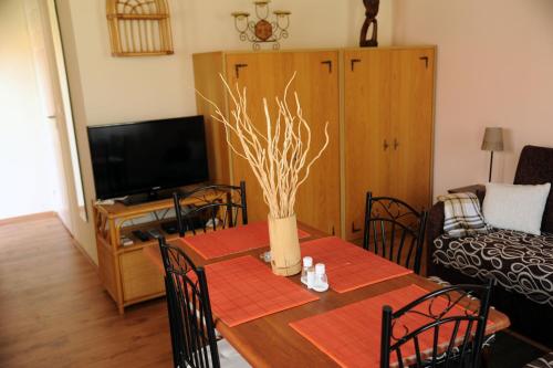 a living room with a table with a vase on it at Arany Szőlő Wellness Apartmanház in Hévíz