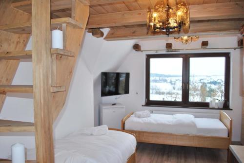 a bedroom with two bunk beds and a window at Dom Wypoczynkowy Szumal in Ostrowsko