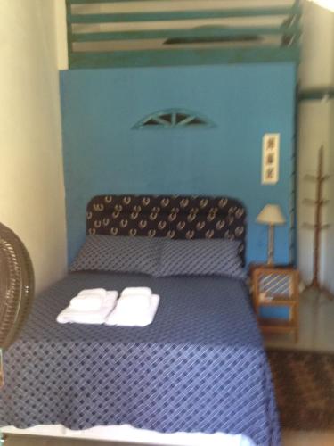 a bedroom with a purple bed with two towels on it at Pousada Peregrino in Barra de Jacuípe