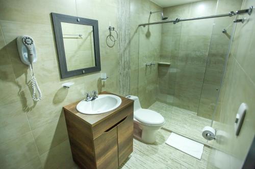 uma casa de banho com um lavatório, um chuveiro e um WC. em Hotel San Blass Boutique em Pasto