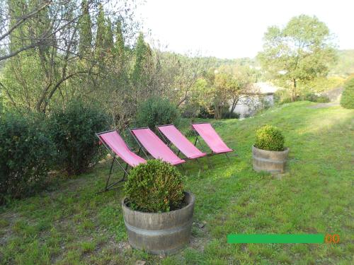 two pink benches sitting on top of a field at Chambre et Gite Le Roc sur l'Orbieu in Saint-Pierre-des-Champs