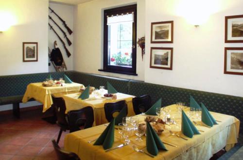 瓦爾迪登特羅的住宿－Chalet Villa Valania，用餐室设有两张带黄桌布的桌子